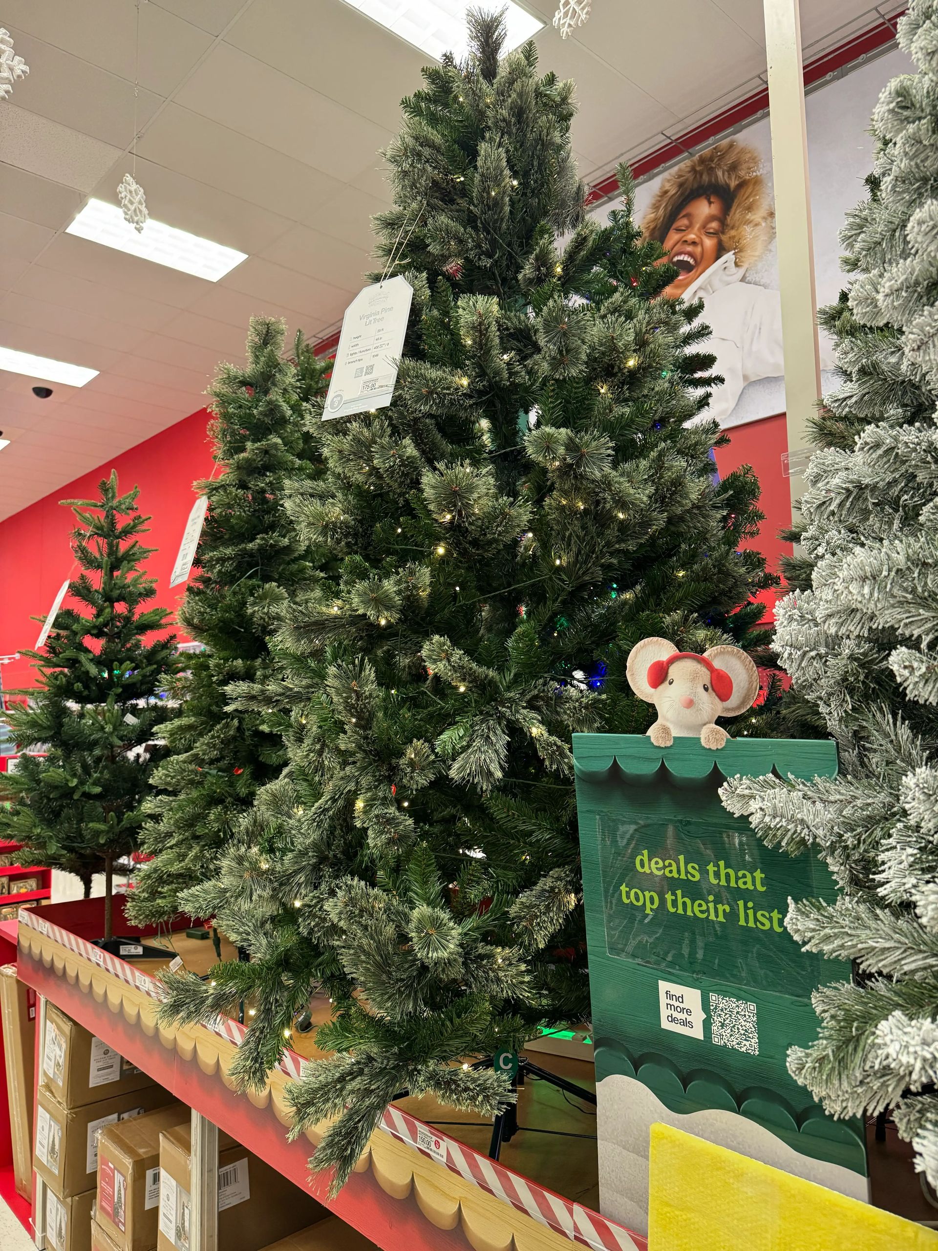 Traditional pine-style tree with moderate PVC branching, visible gaps, warm white mini bulbs throughout