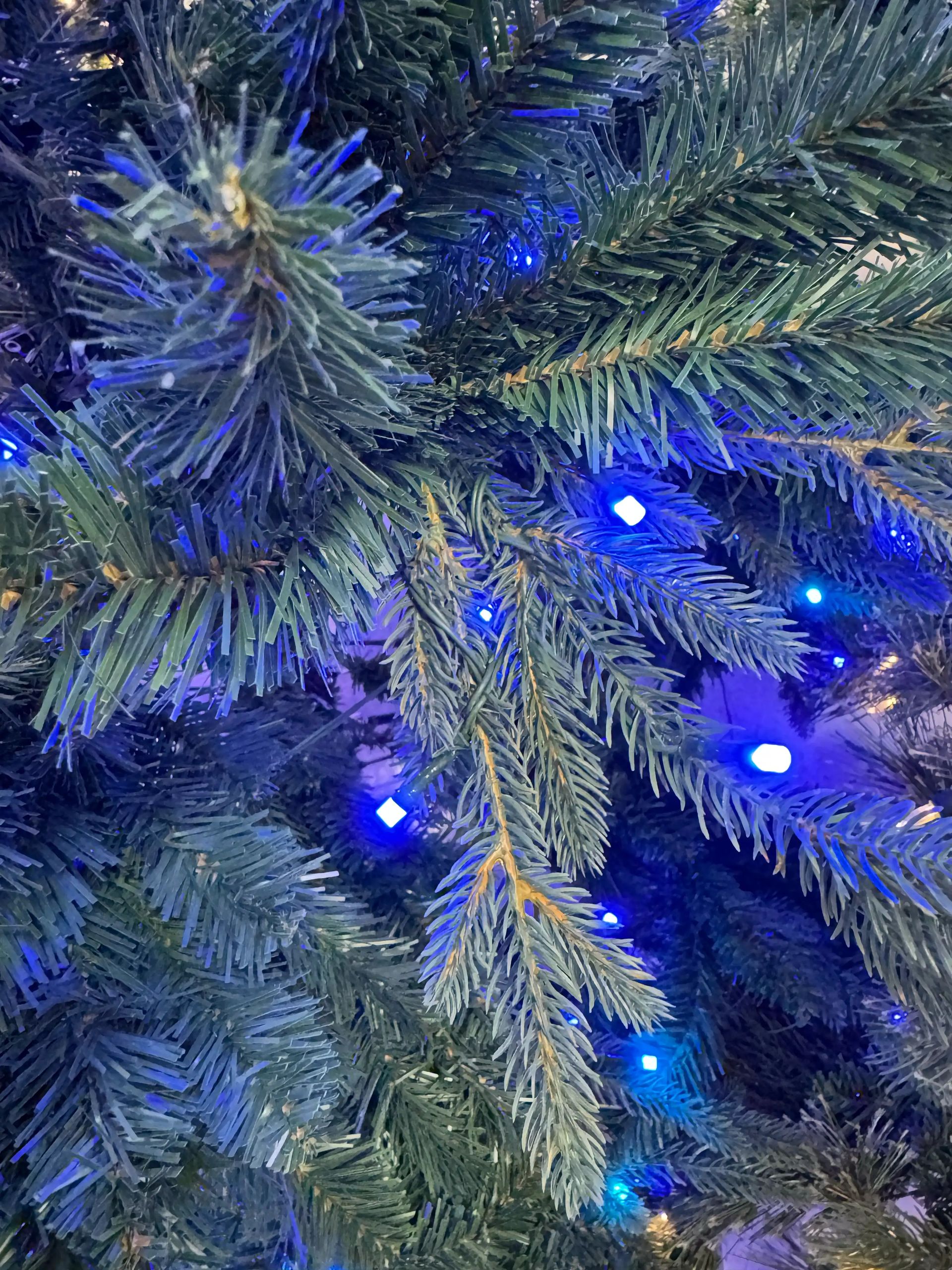 Mixed PVC/PE spruce needles with blue LED lights, moderate density, visible branch structure between tips