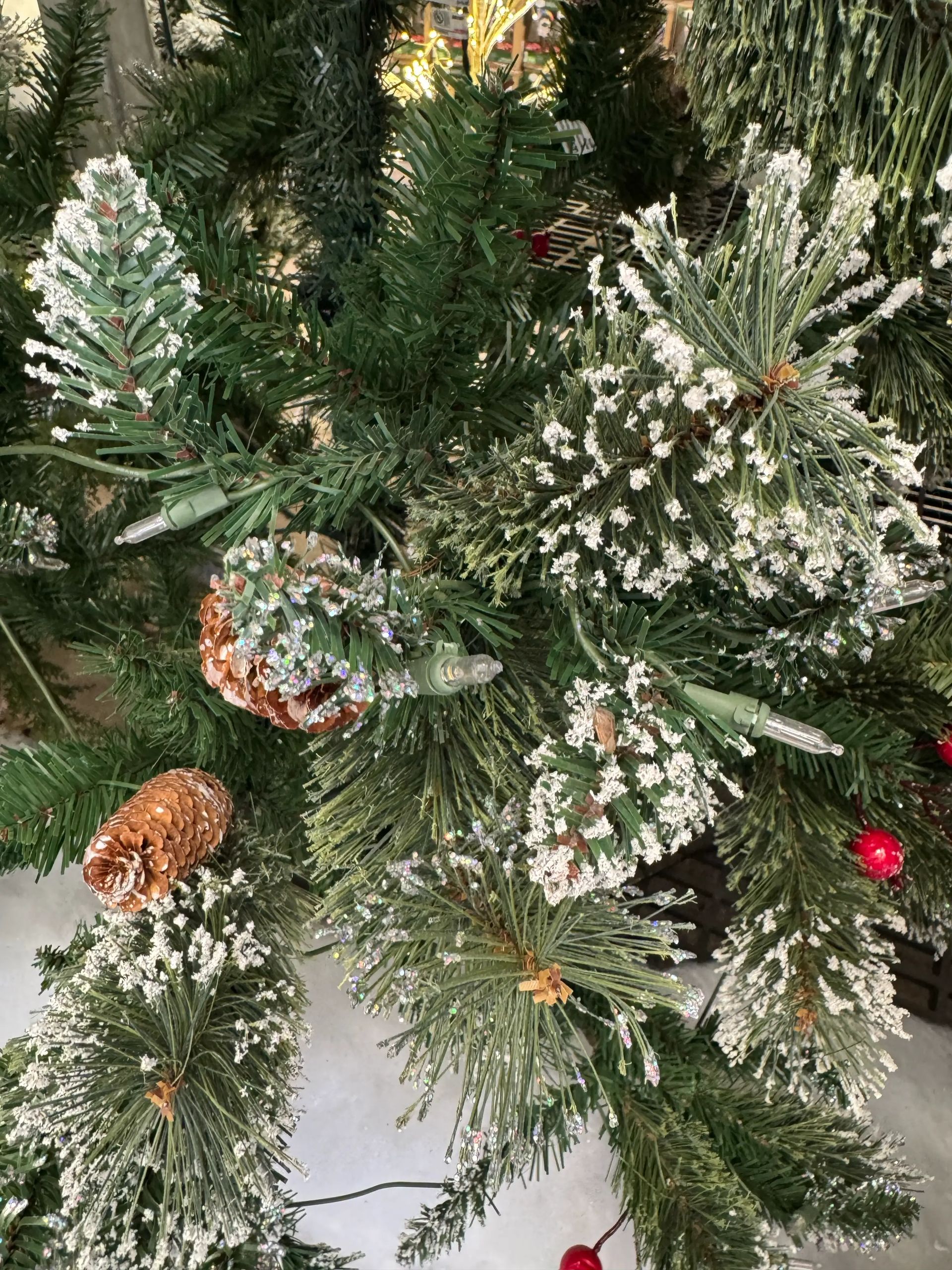 Mixed pine branches with heavy white flocking/glitter, natural pinecones, warm white LED lights, frosted pine sprigs