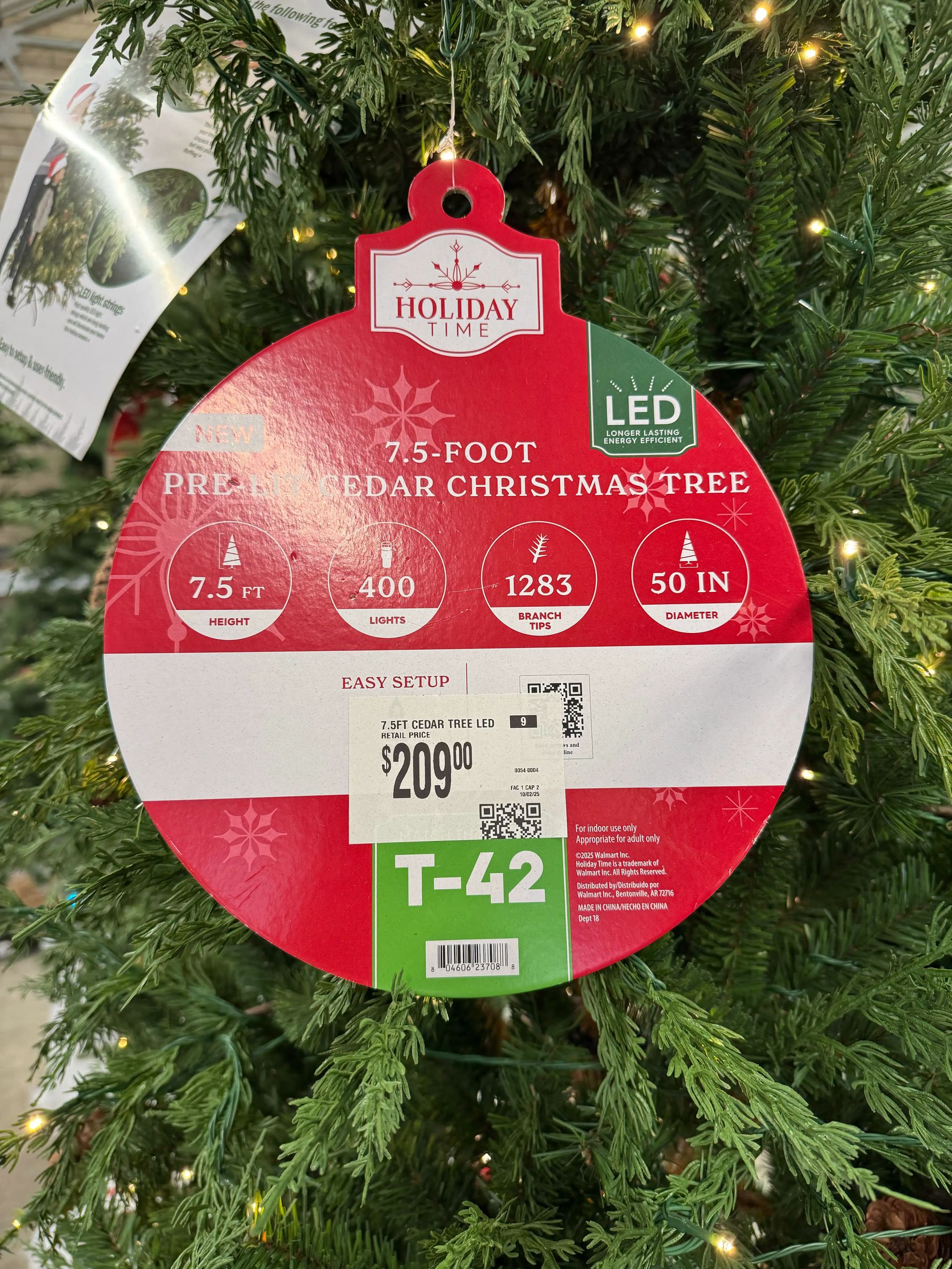 Product tag showing 7.5ft cedar tree specs: 50in diameter, 400 lights, 1283 branch tips, $209, LED green badge