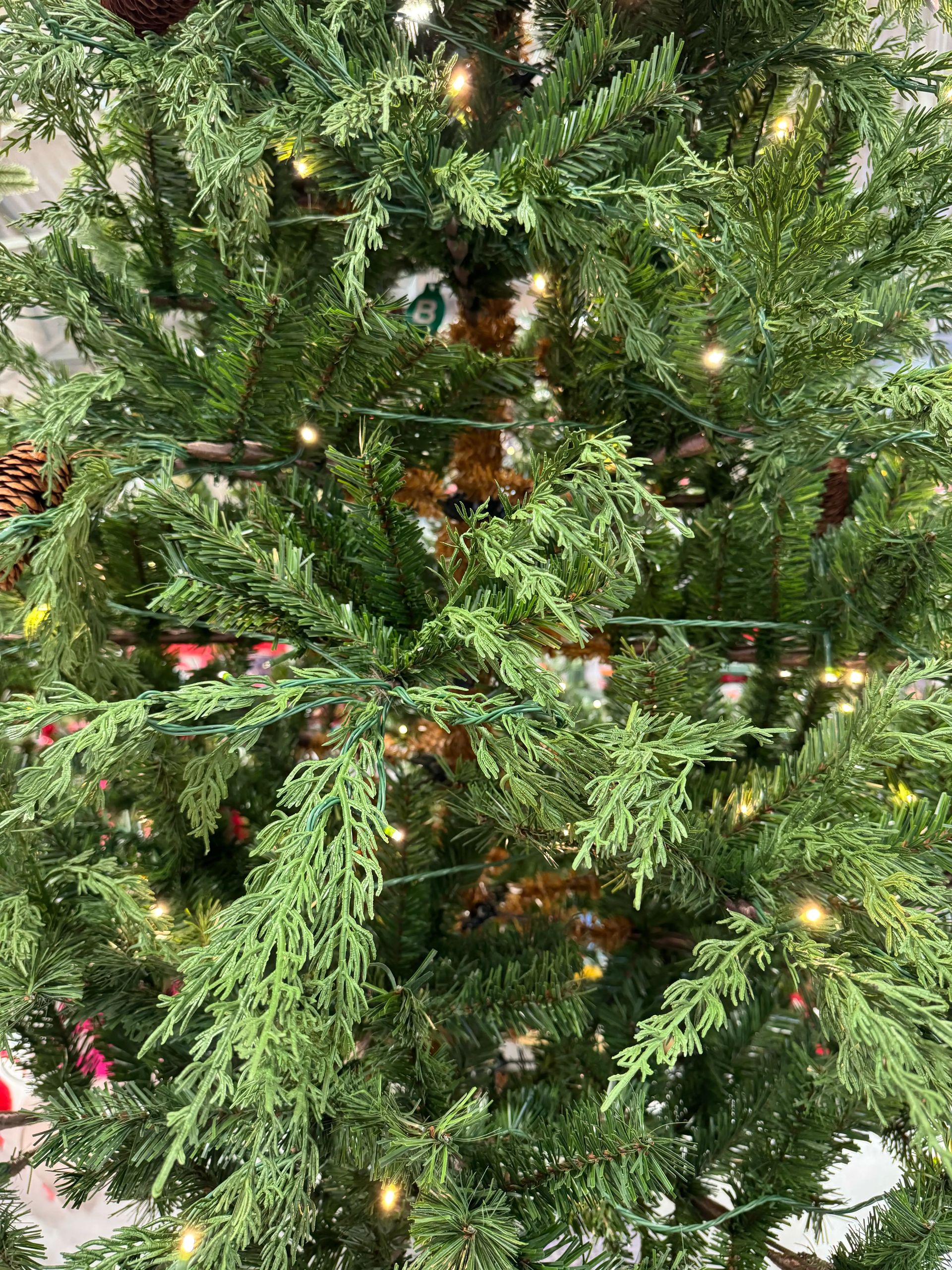 Mixed PVC and molded PE cypress-style needles with warm white lights, moderate branching, some visible gaps