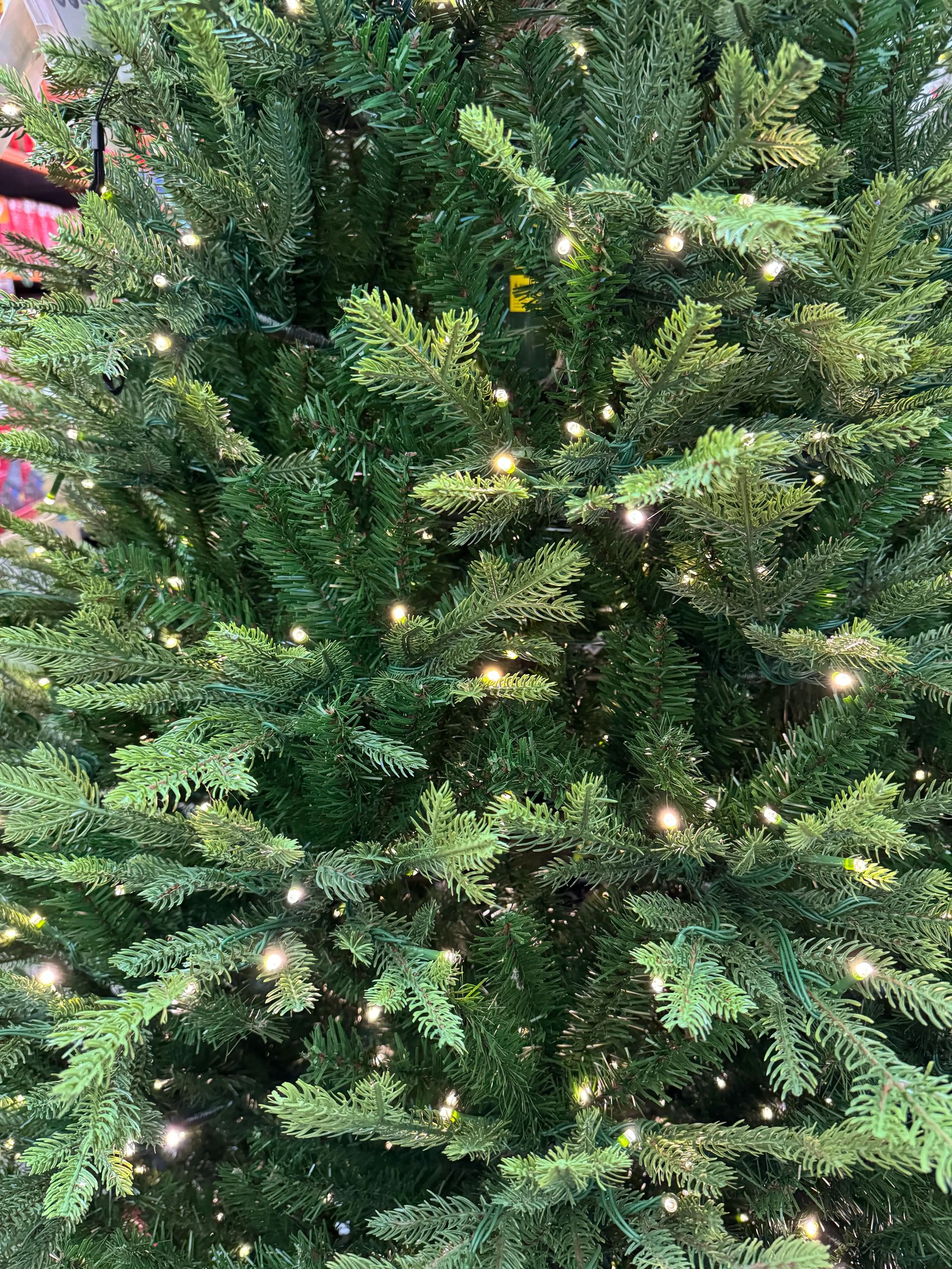 Mixed PVC and PE fir needles showing dense branching, warm white micro LEDs evenly distributed throughout interior