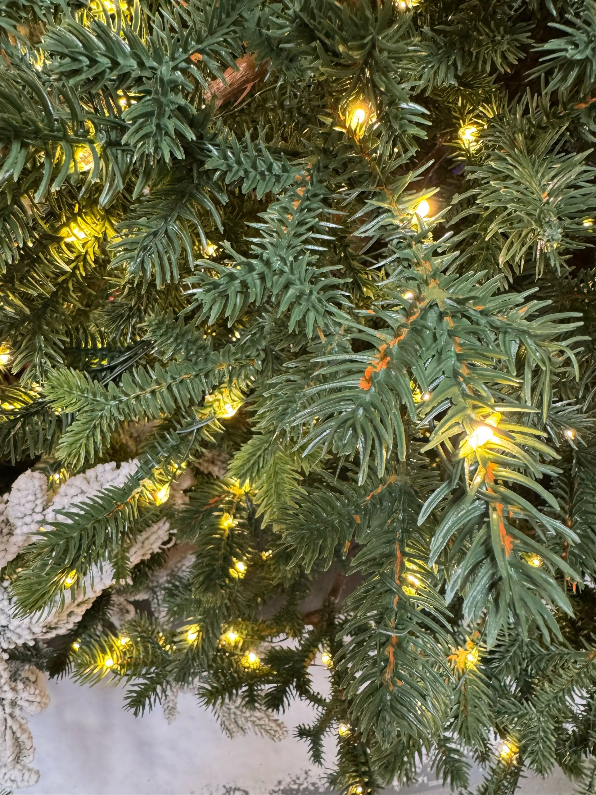 Dense molded PE fir needles in green with warm white micro LED lights distributed throughout, minimal visible gaps