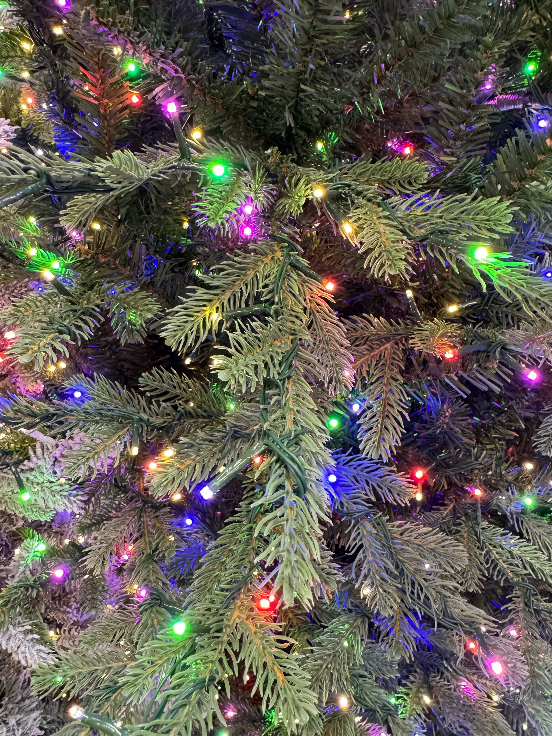 Mixed PVC and PE fir needles, dense multicolor LED lights throughout branches, realistic needle texture visible