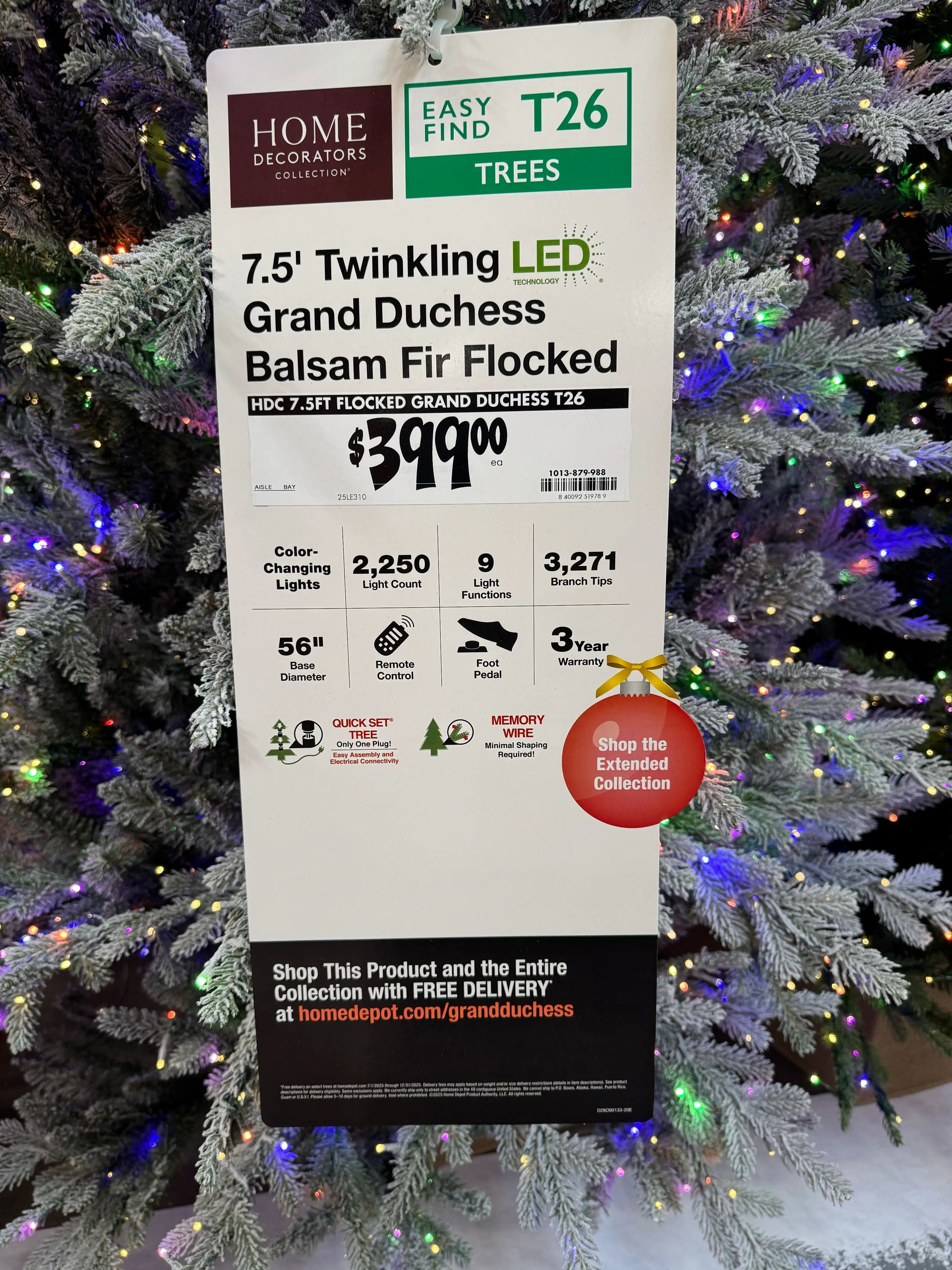 Product tag showing 7.5ft flocked tree specs: $399, 2,250 color-changing lights, 3,271 tips, remote control, 3yr warranty