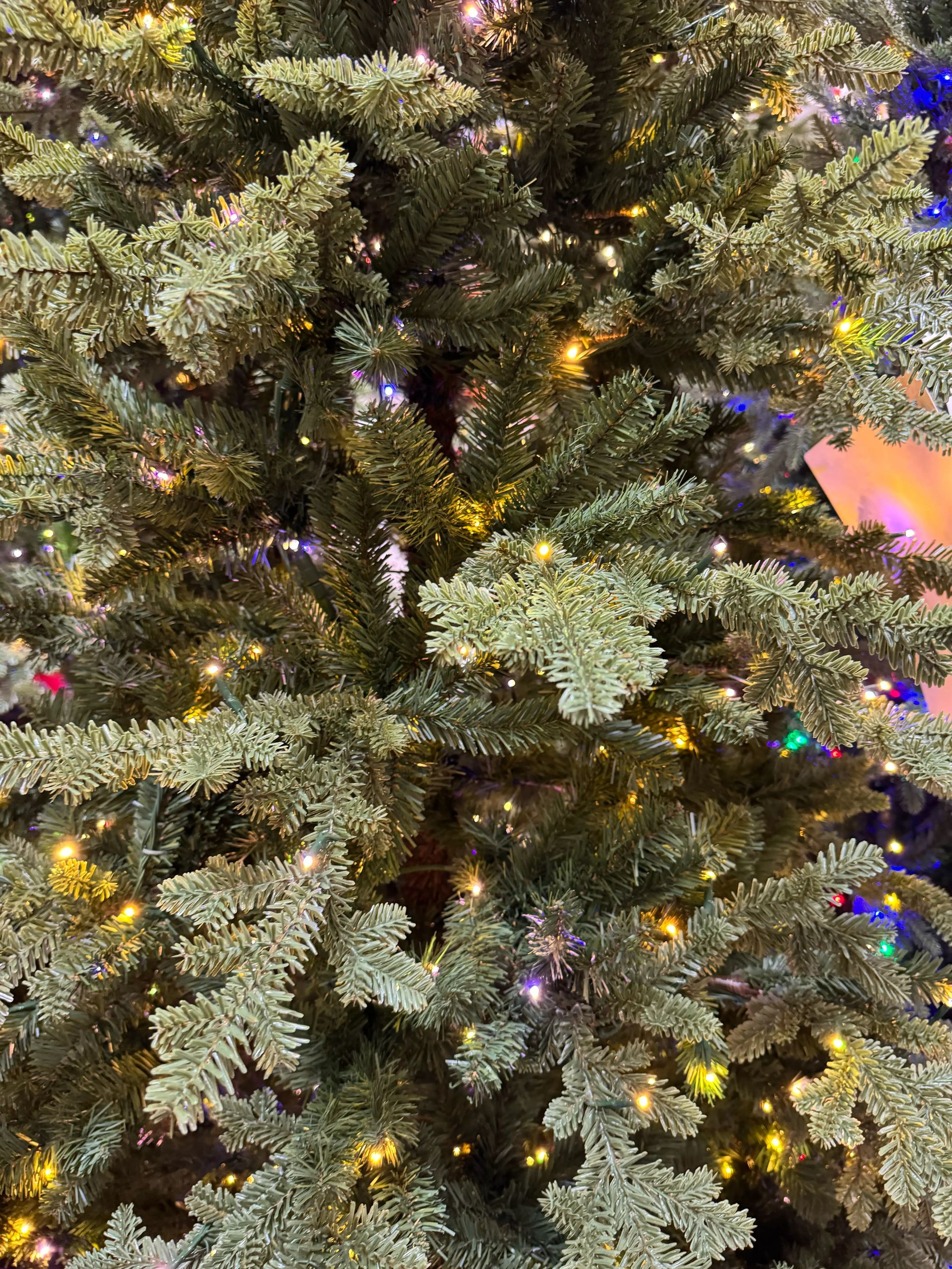Mixed PVC and molded PE fir needles with warm white and multicolor micro LEDs, moderate density, some visible gaps