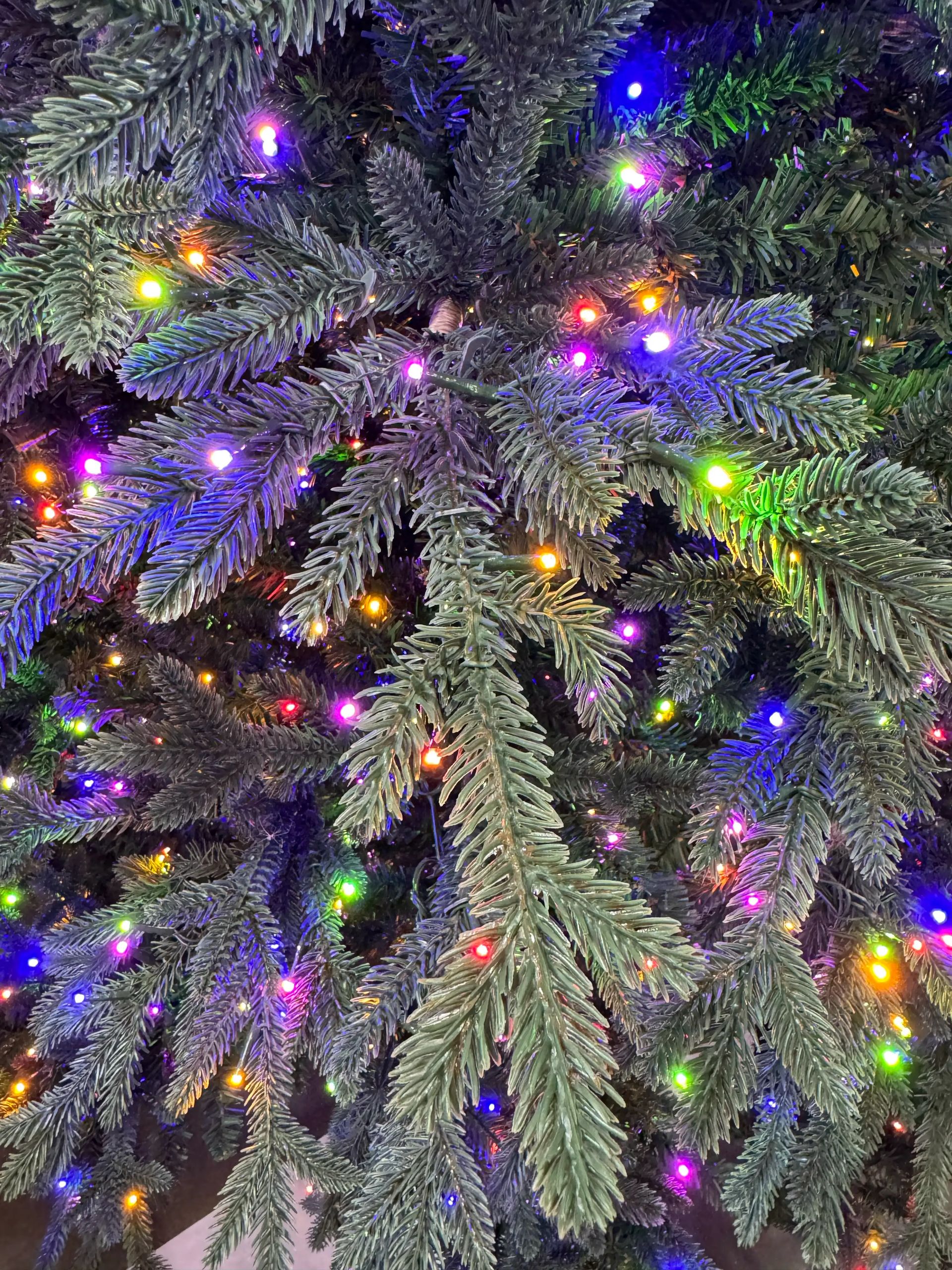 Dense mixed PVC/PE fir needles with multicolor LED lights throughout, full coverage with minimal gaps visible