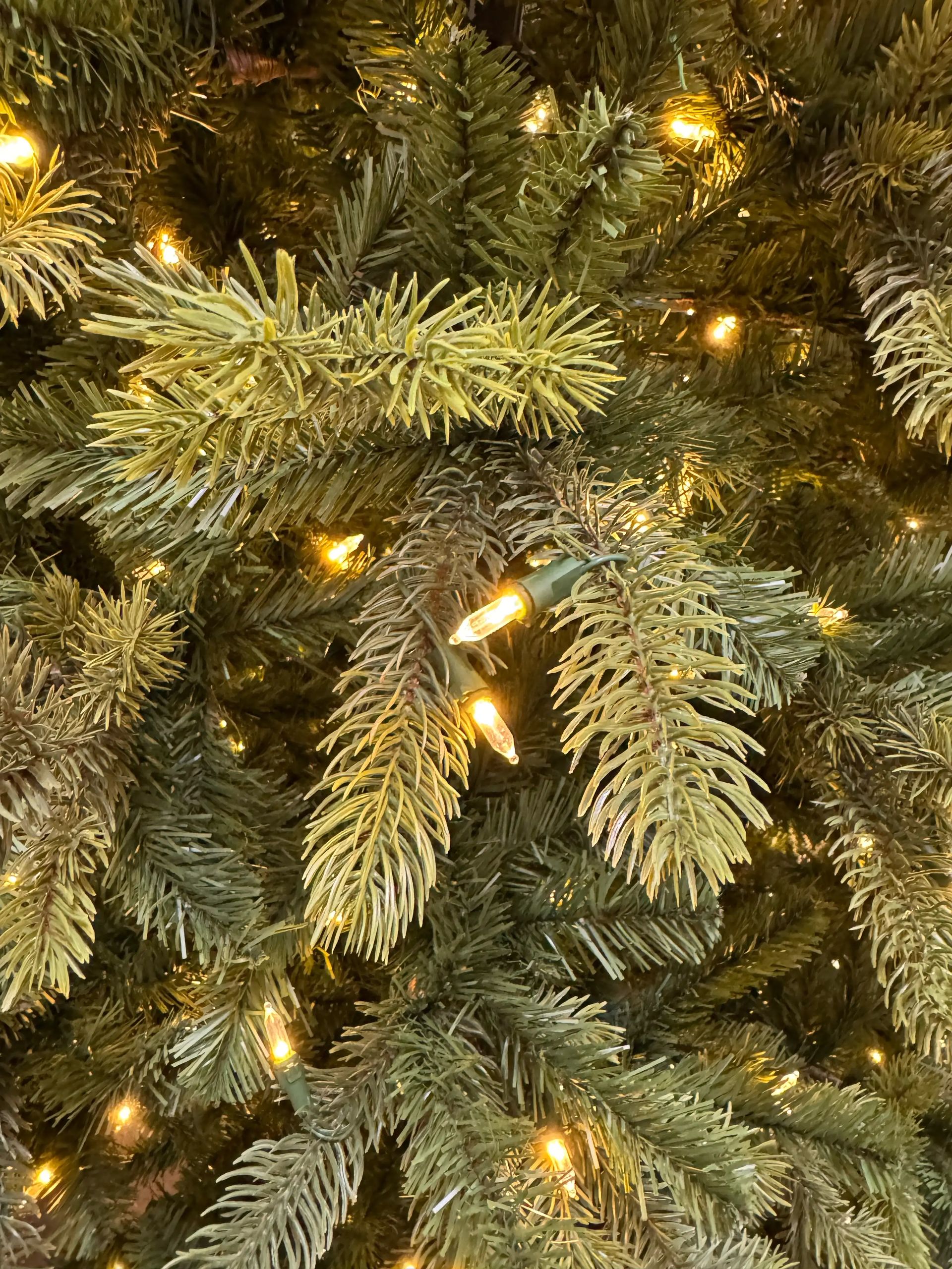 Mixed PVC and PE spruce needles in sage-green tones, warm white mini bulbs evenly distributed through branches