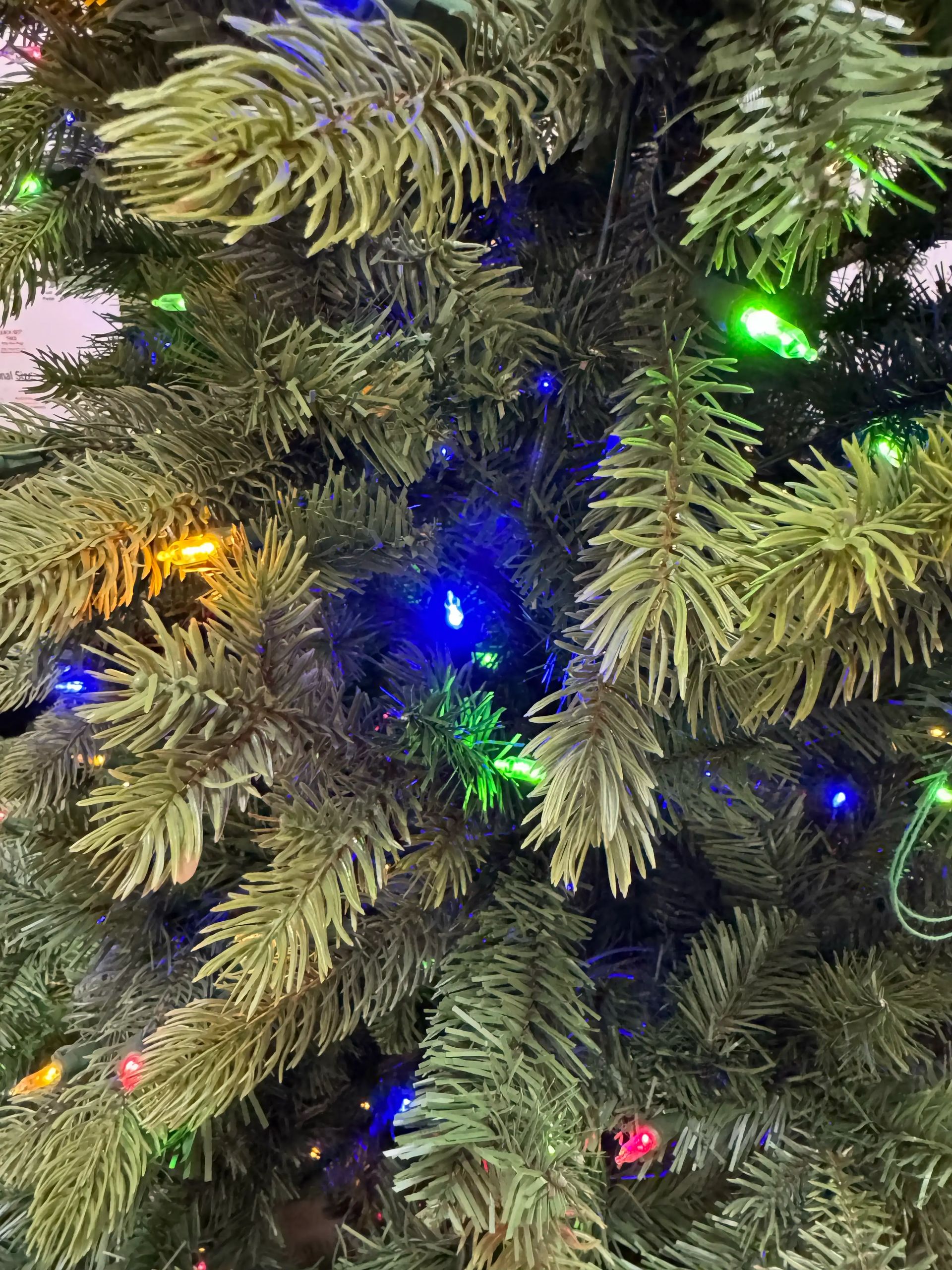 Mixed PVC/PE spruce needles with multicolor mini bulbs, moderate density, visible branch structure, even light spacing