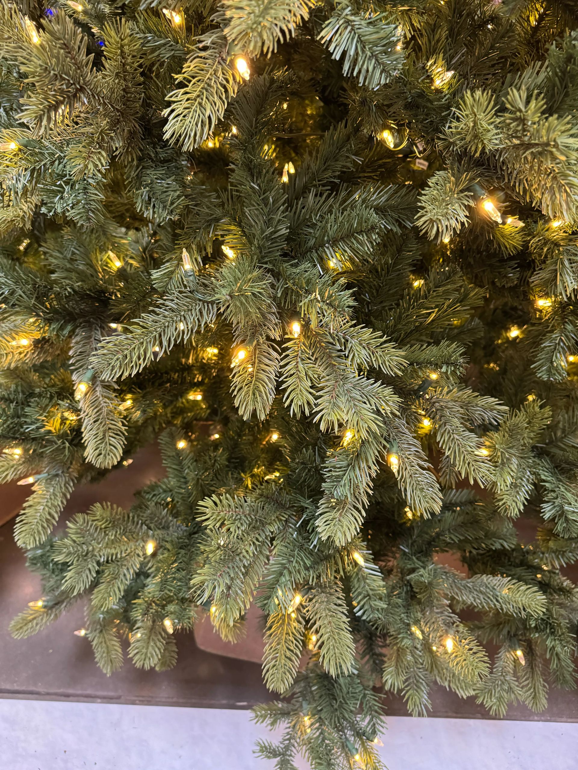Close-up of dense mixed PVC/PE spruce needles with warm white lights, realistic texture, minimal gaps visible