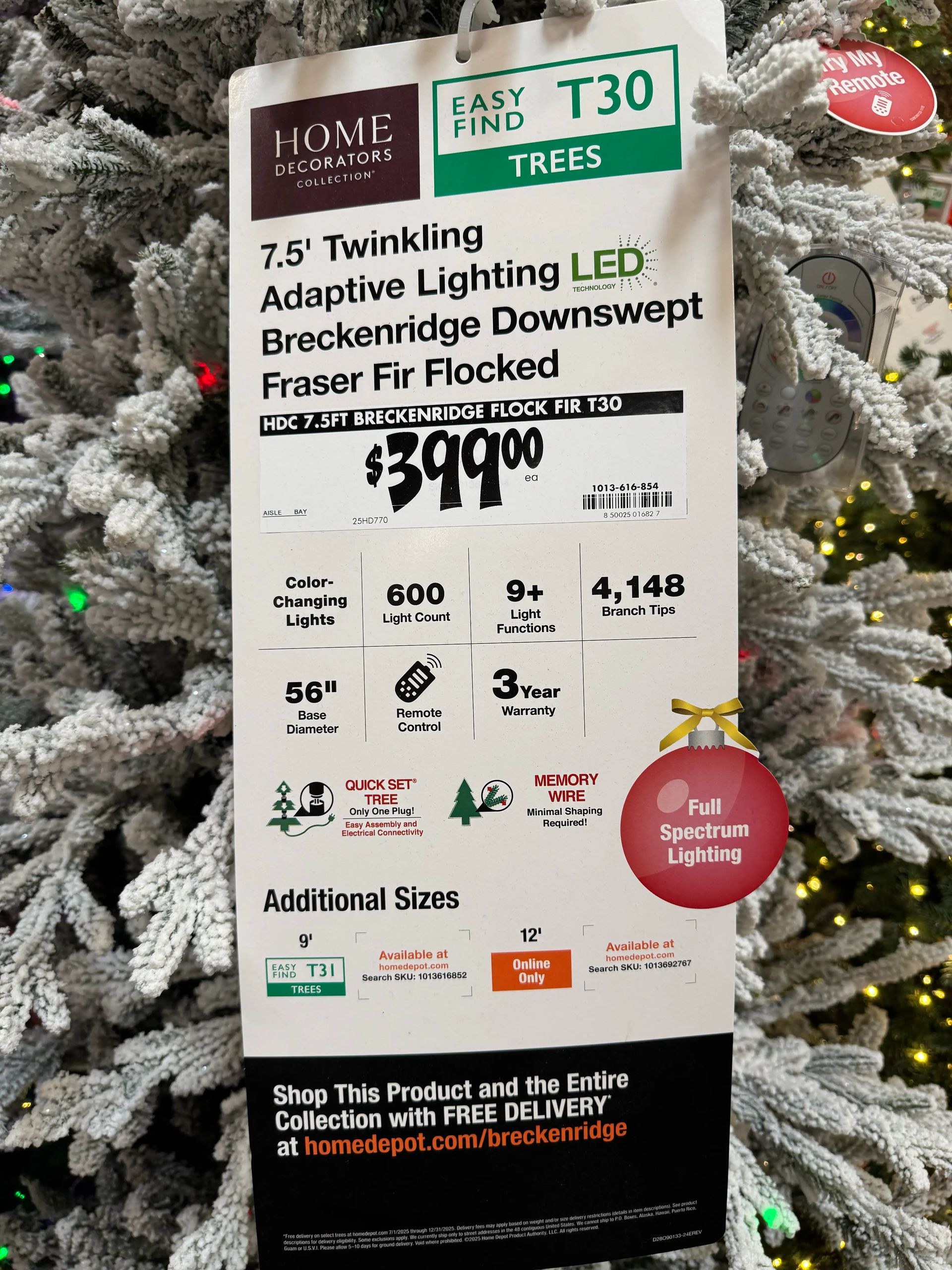 Product tag: 7.5ft flocked tree, $399, 600 LED lights, 4,148 tips, 56in base, remote control, 3-year warranty