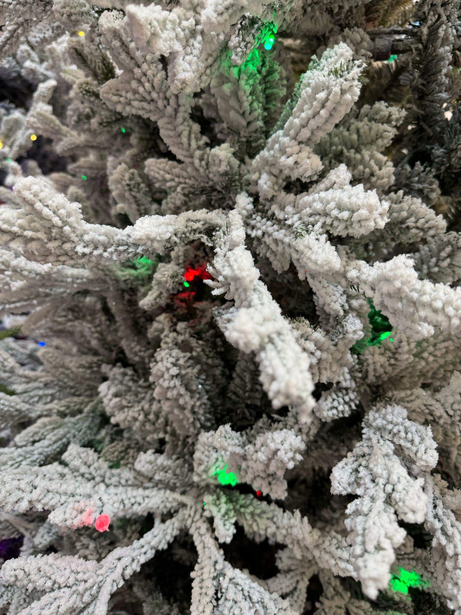 Heavy white flocked PVC branches with multicolor LED lights, dense frosting coverage, moderate branching density