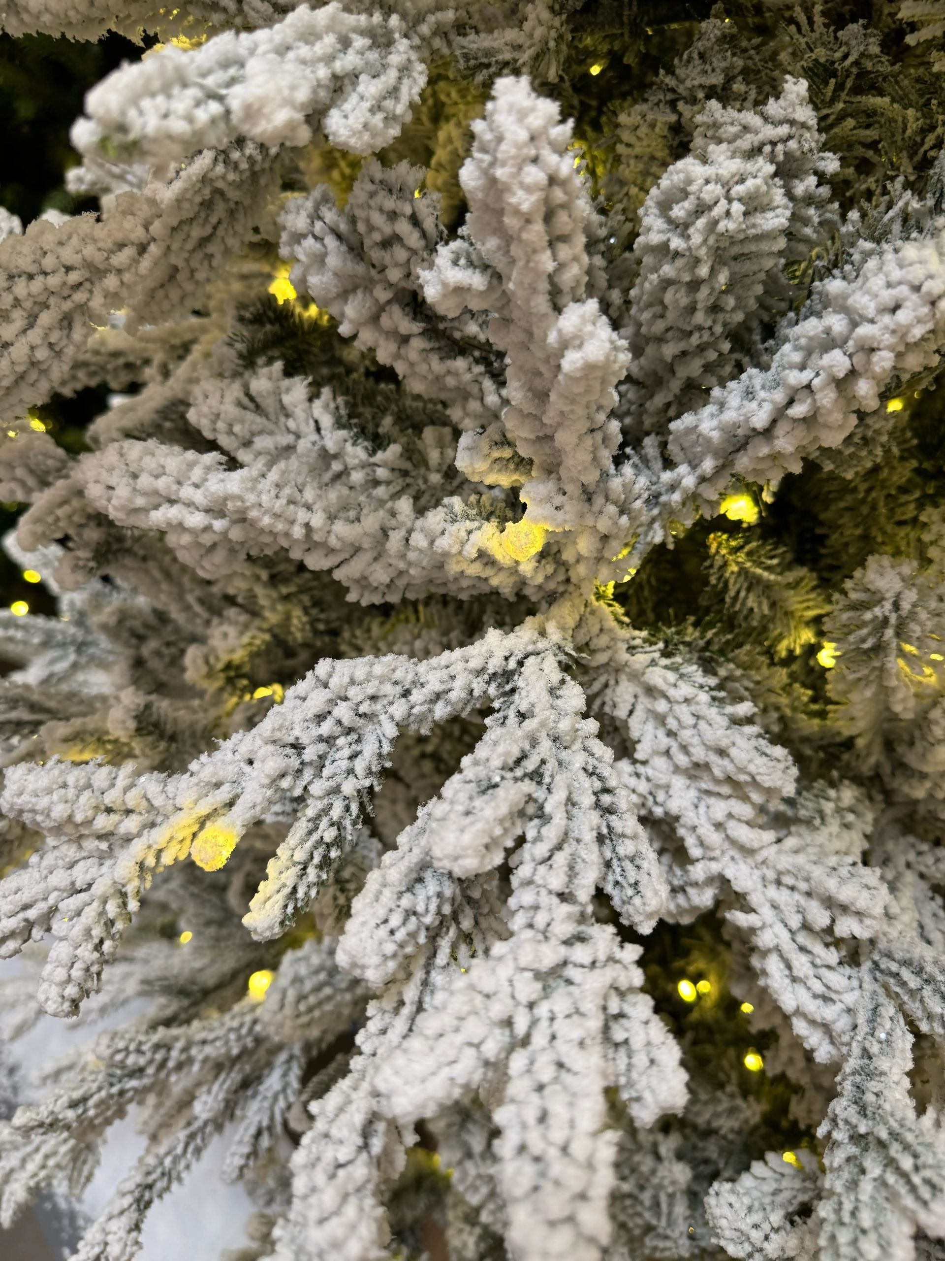 Dense mixed PVC/PE fir needles with heavy white flocking, warm white micro LEDs visible throughout branches