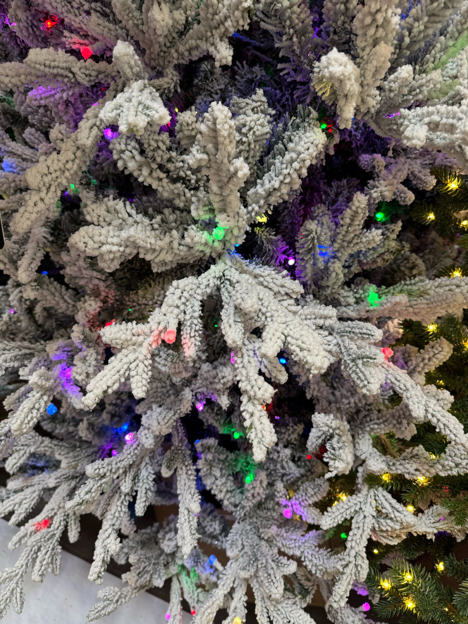Heavy white flocked branches with dense PE/PVC mix needles, multicolor micro LEDs throughout, minimal gaps visible