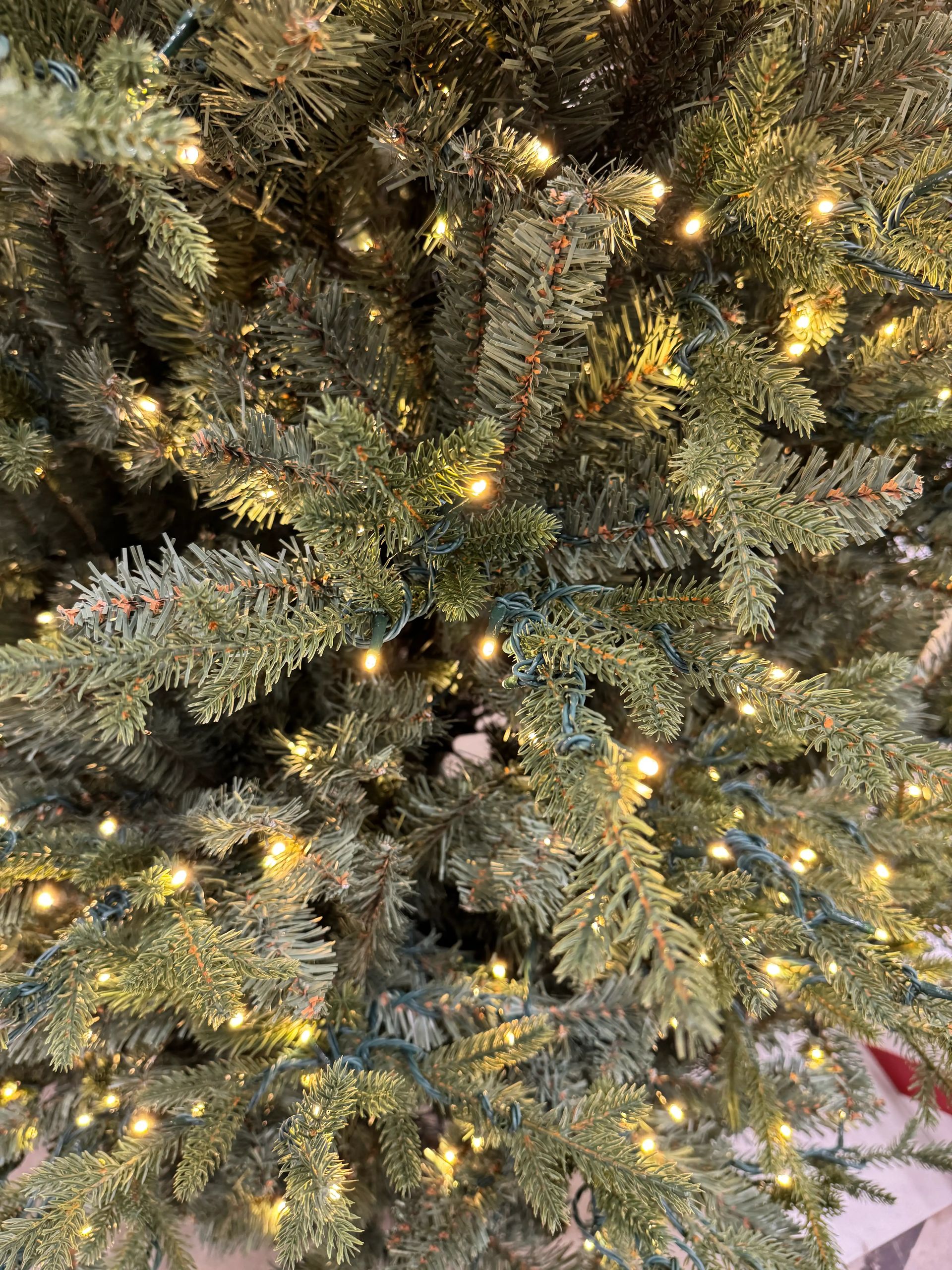 Mixed PVC and molded PE fir needles, warm white LED lights evenly distributed, moderate density with some visible gaps