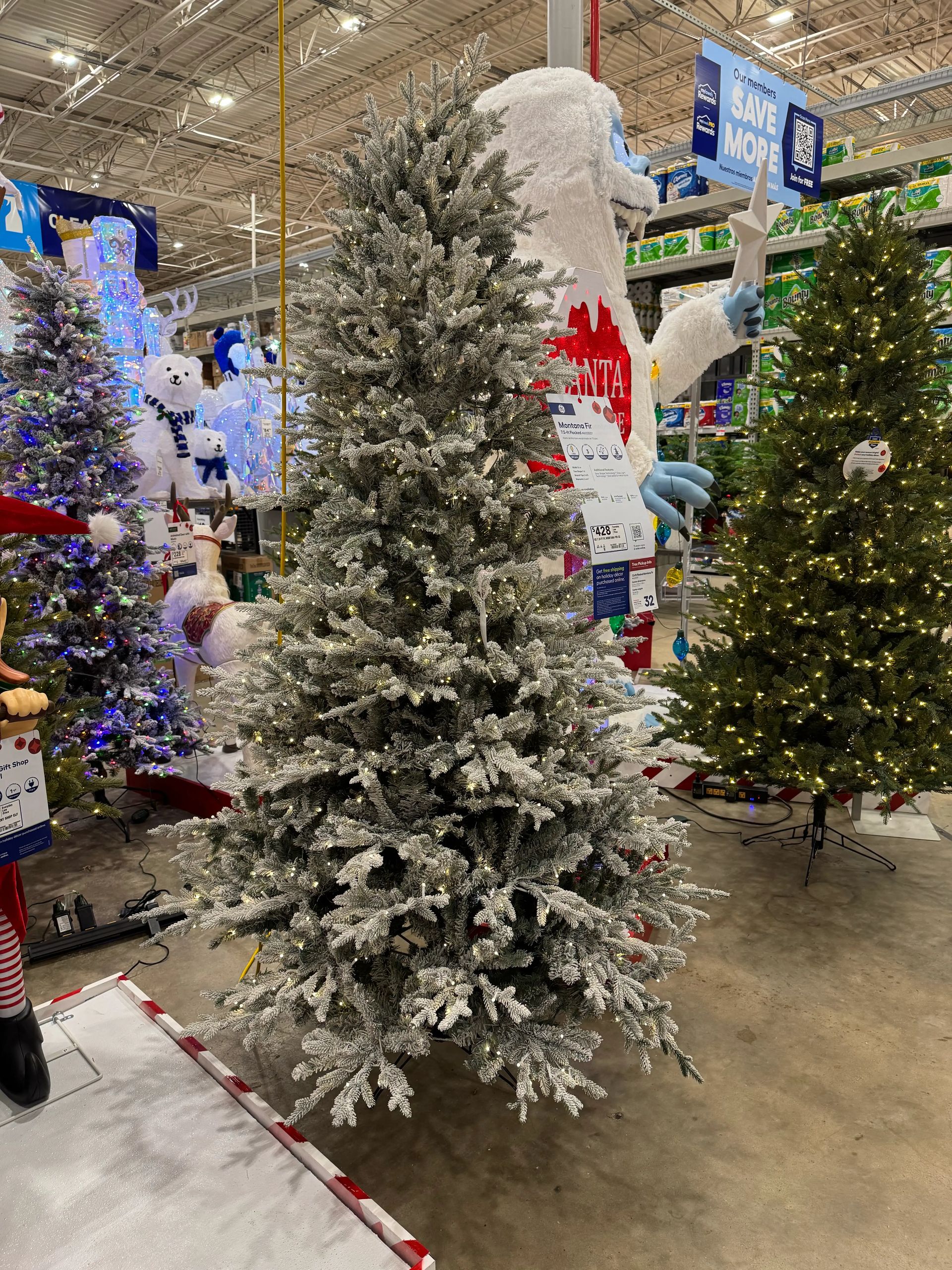 Heavily flocked fir-style tree with white frosted PVC needles, dense branching, warm white lights throughout