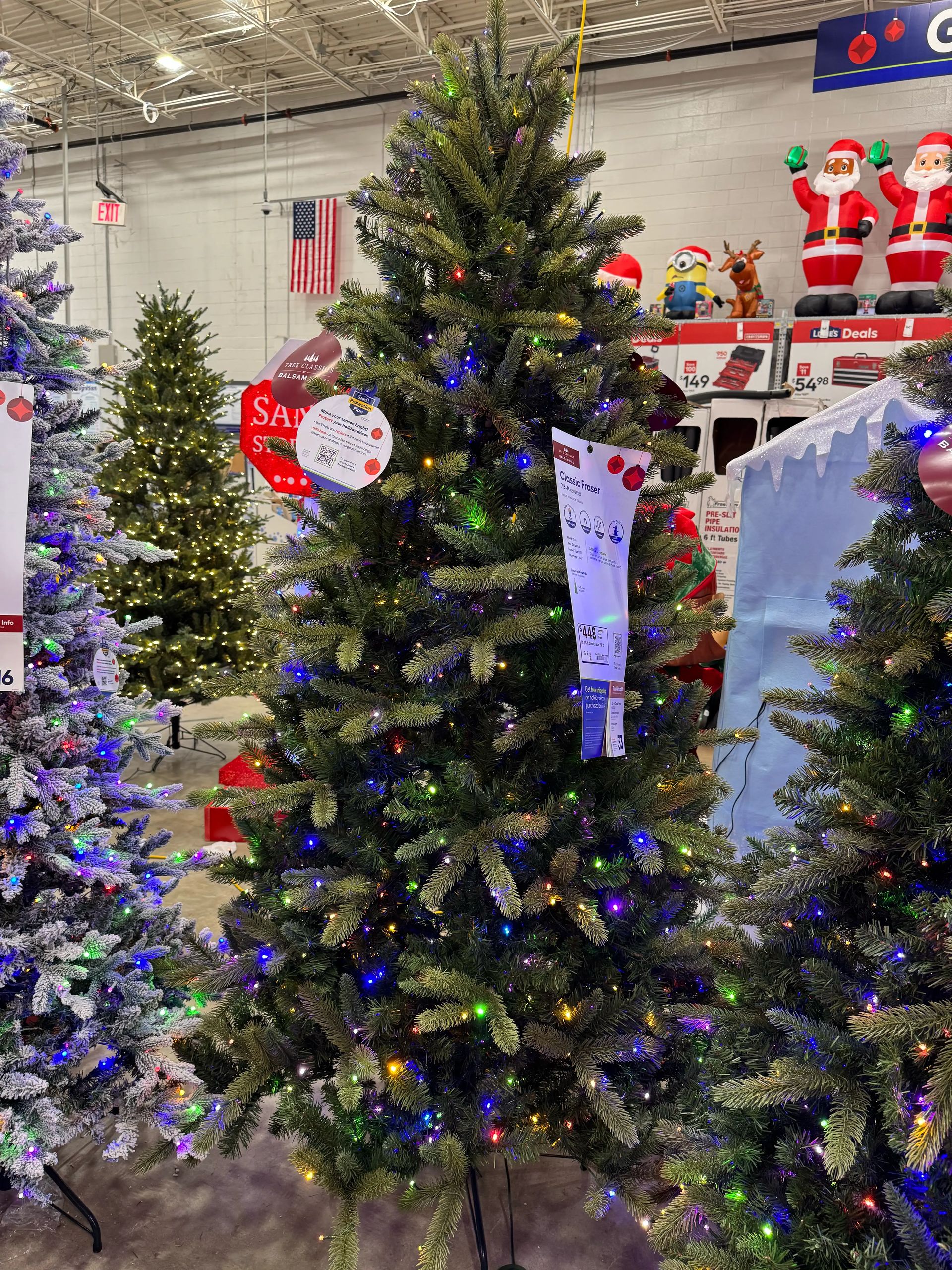 Mixed PVC/PE fir with moderate fullness, some visible gaps, multicolor mini bulbs densely distributed throughout