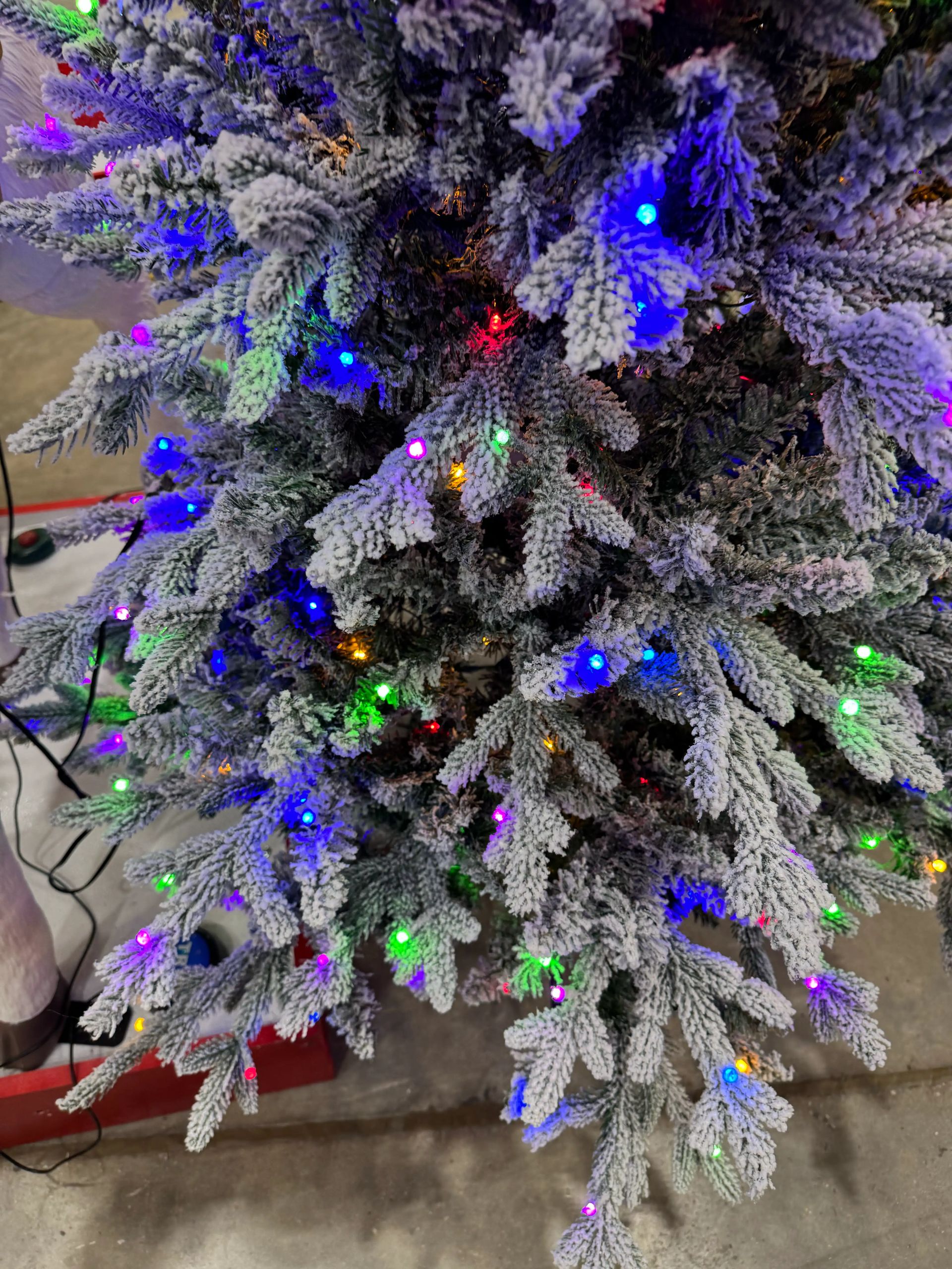 Heavy white flocked fir branches with mixed PVC/PE needles, multicolor LED lights, dense coverage, minimal gaps visible