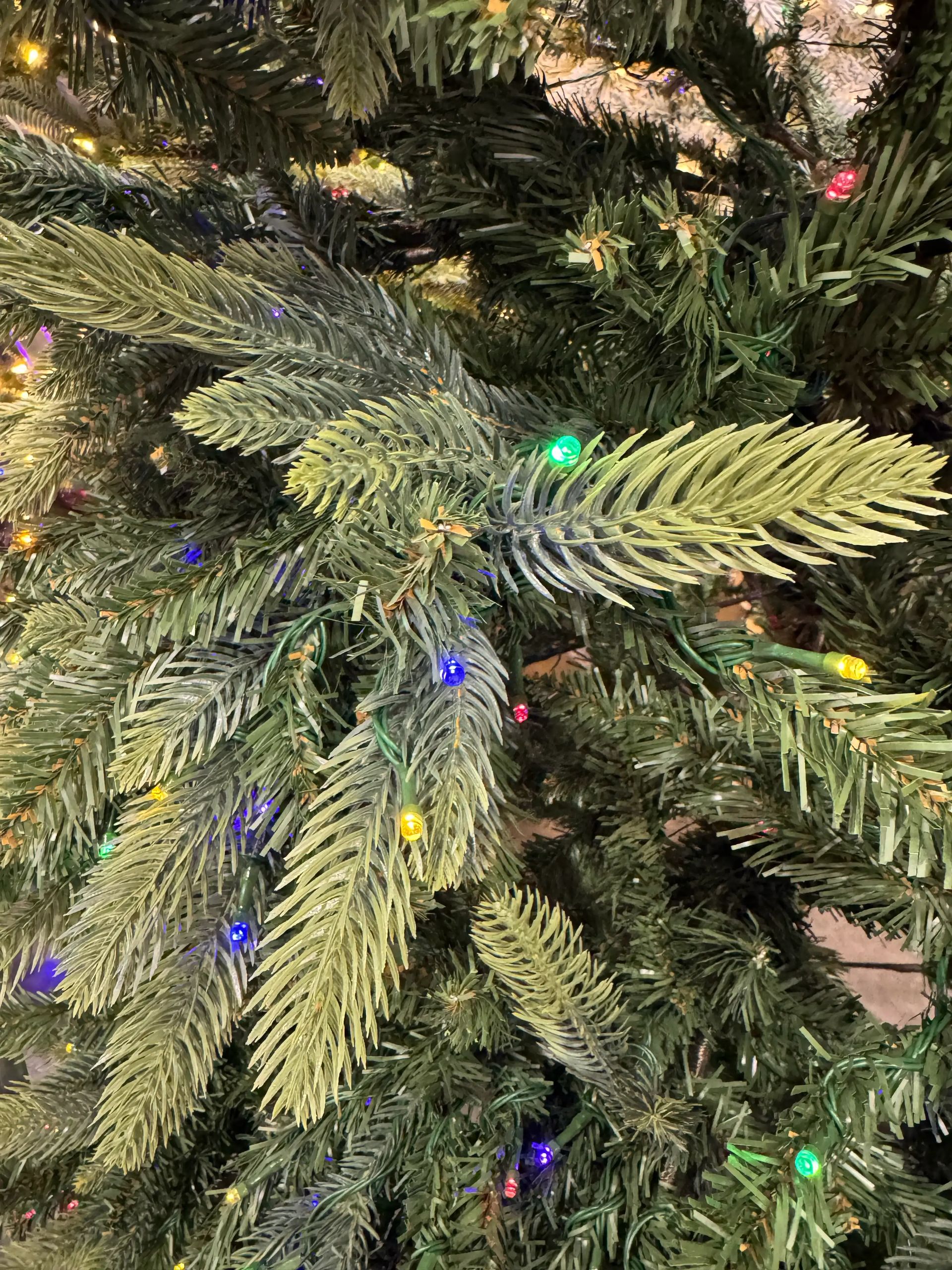 Mixed PVC/PE needles with multicolor mini bulbs, moderate density branches showing some stem gaps and brown inner core