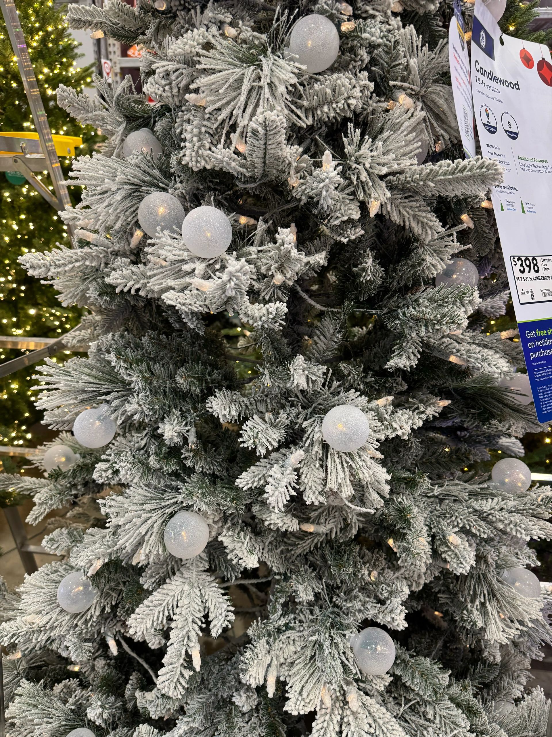 Heavily flocked pine-style tree with mixed PVC/PE needles, white frosted ornaments, warm white mini bulbs, dense full shape