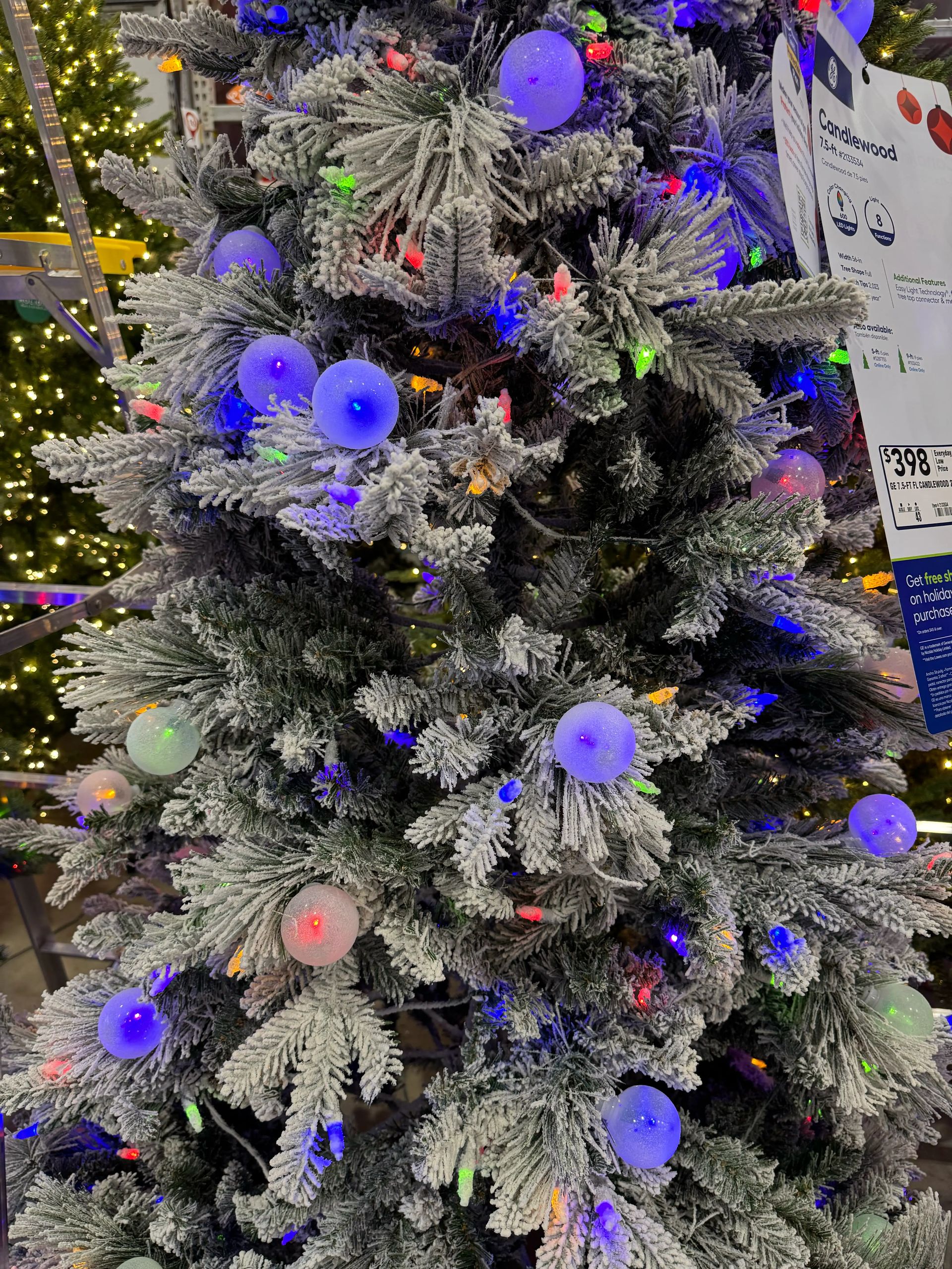 Flocked pine-style tree with gray-white coating, mixed PVC/PE needles, large purple globe bulbs and multicolor mini LEDs