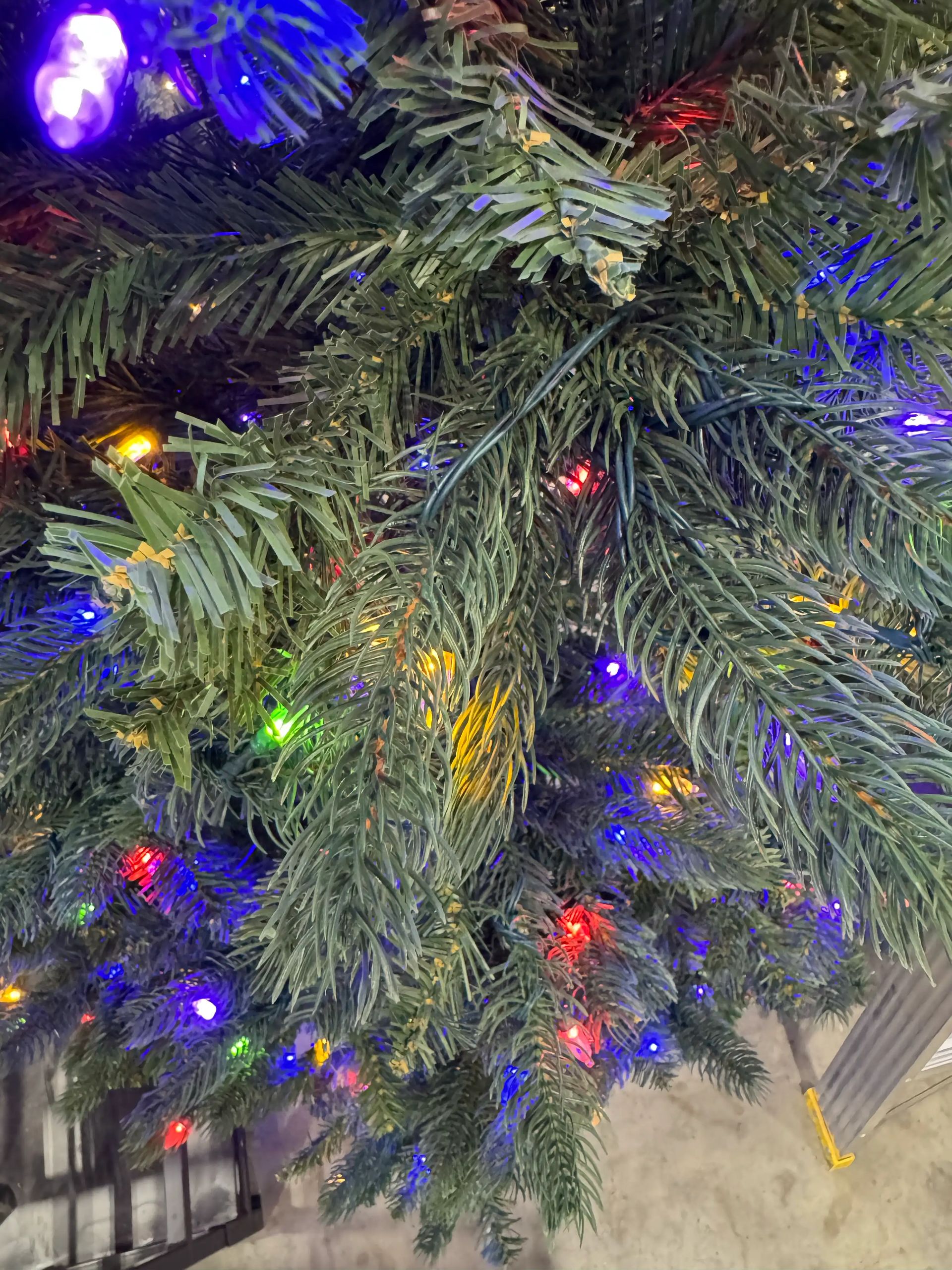 Mixed PVC/PE spruce needles with multicolor mini bulbs, moderate density, visible brown stems and branch structure