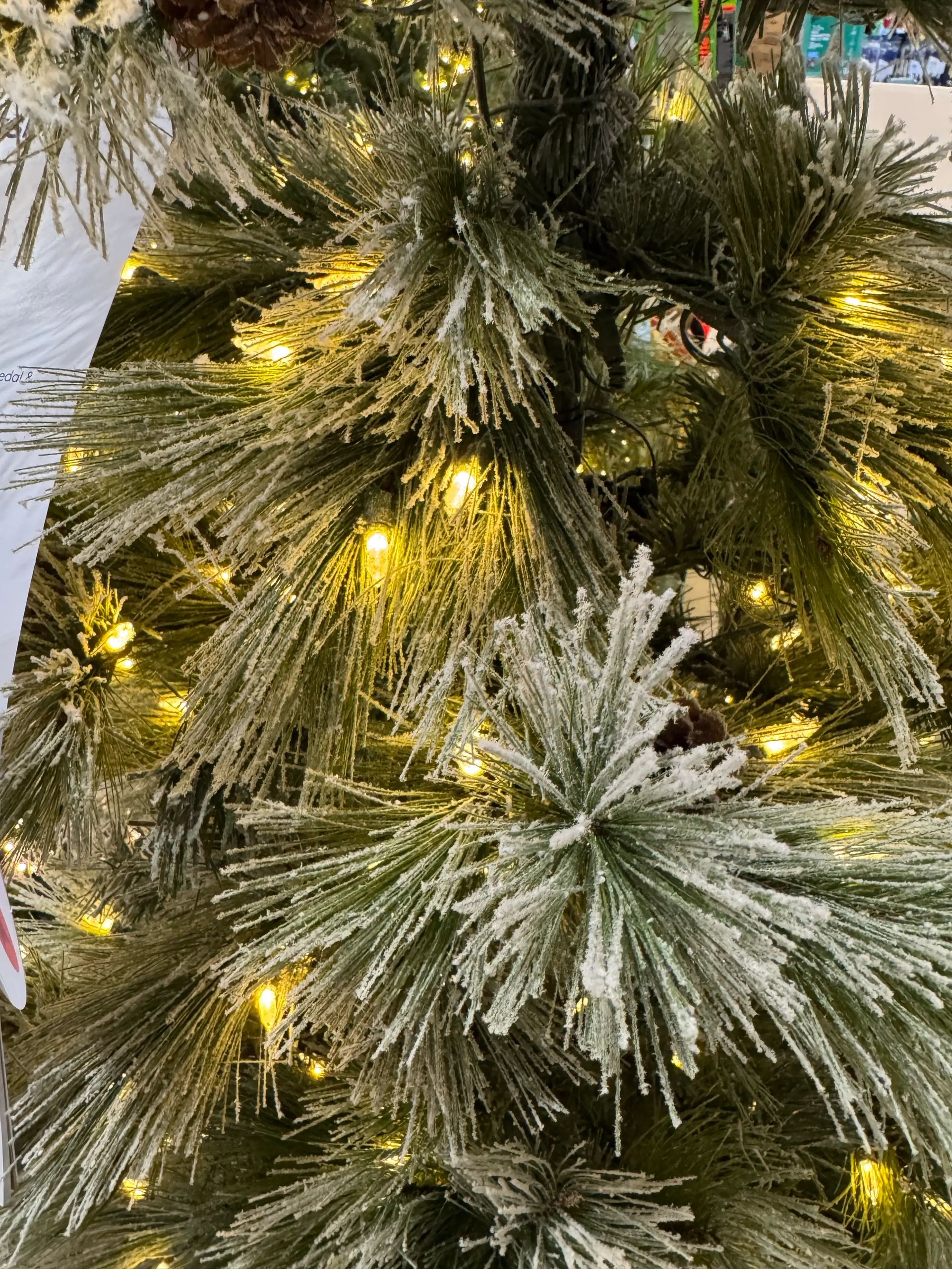 Long PVC pine needles with white flocking, warm white LED lights scattered throughout, moderate branch density
