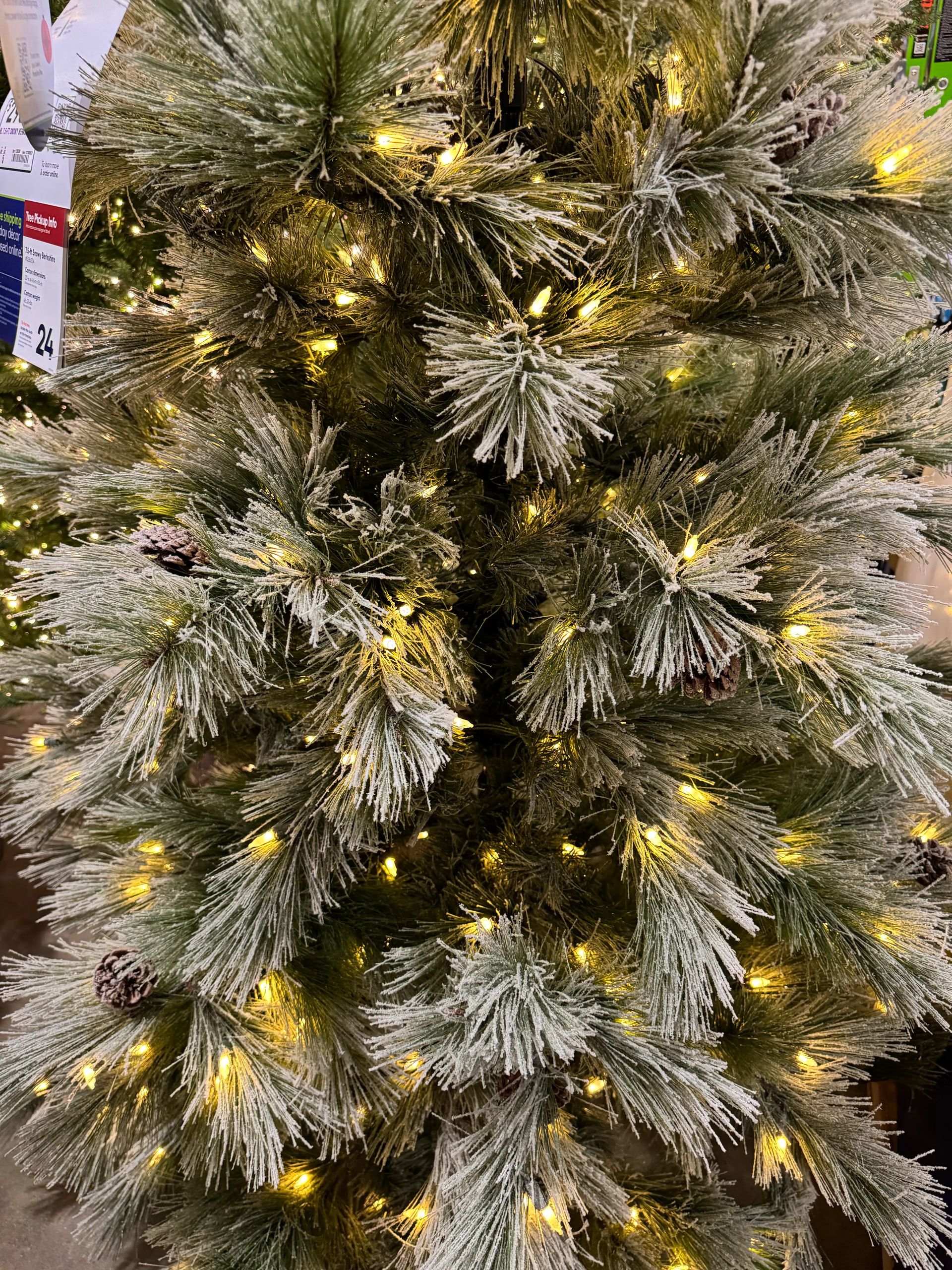 Mixed PVC pine needles with light white flocking, warm white LED lights throughout, moderate coverage with some gaps