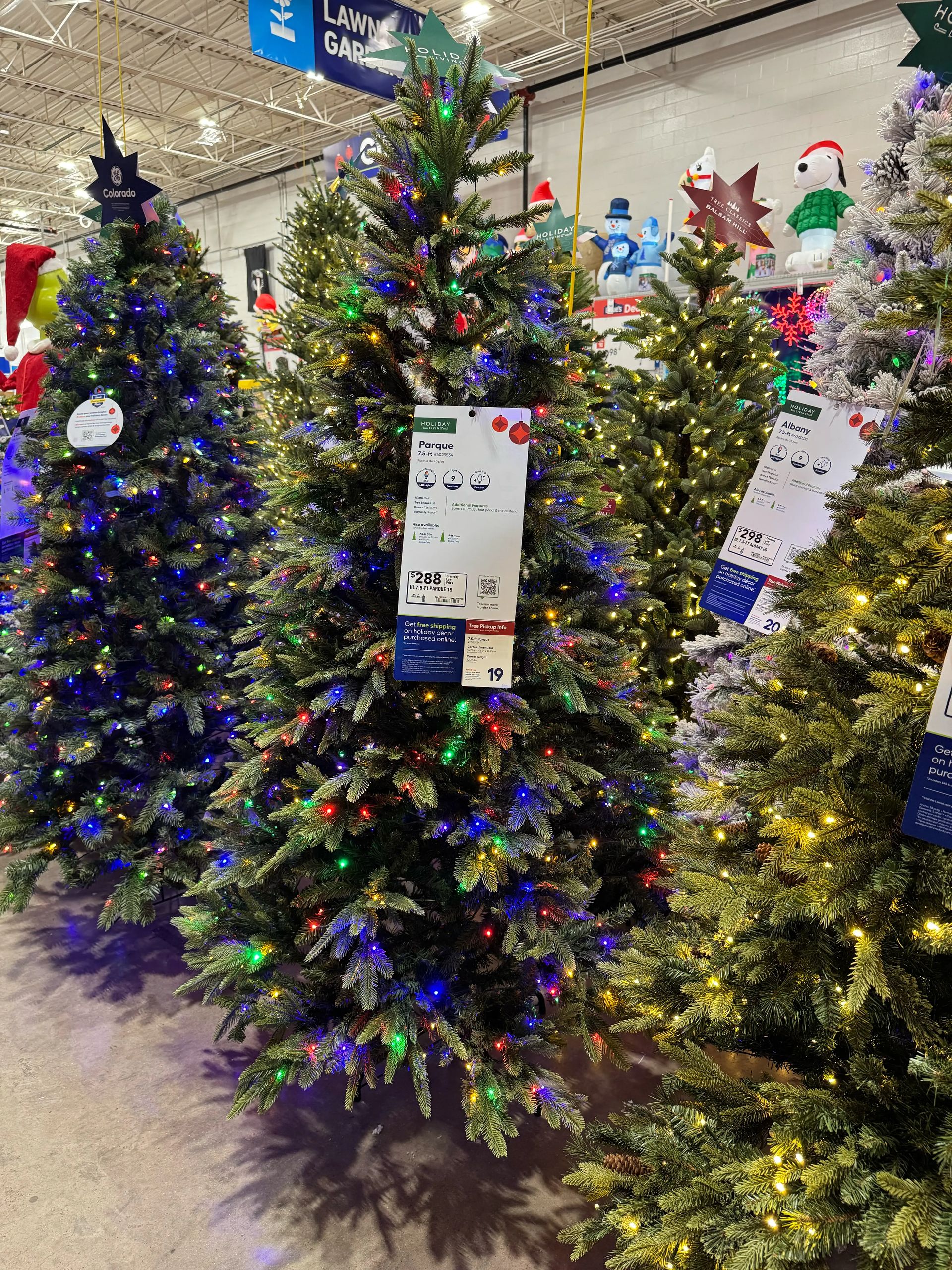 Mixed PVC/PE fir with moderate branching, some gaps visible, multicolor LED lights throughout, full natural shape