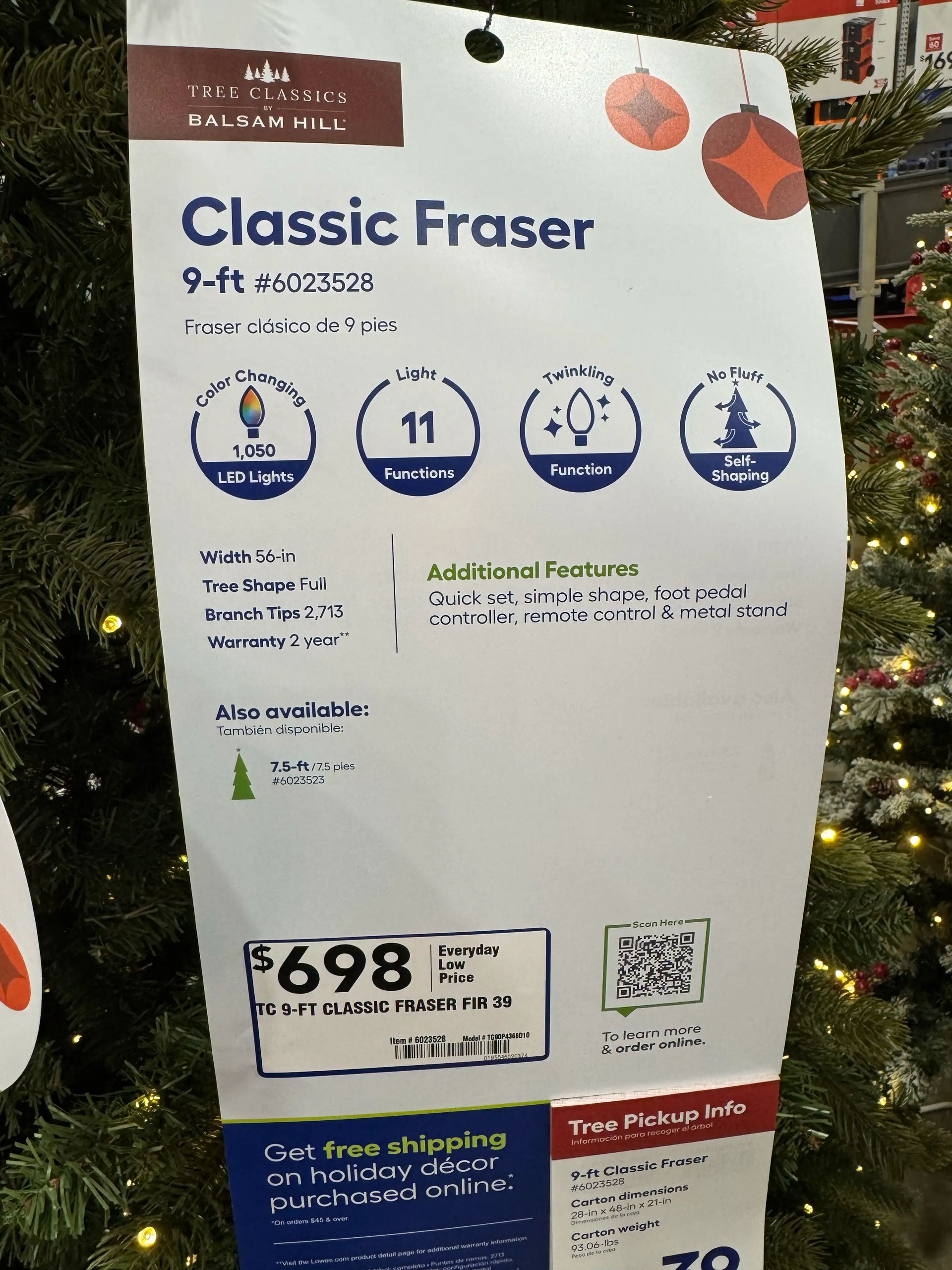 Product sign: 9-ft Fraser fir, 1,050 LED lights, 11 functions, 2,713 branch tips, $698, includes remote & metal stand