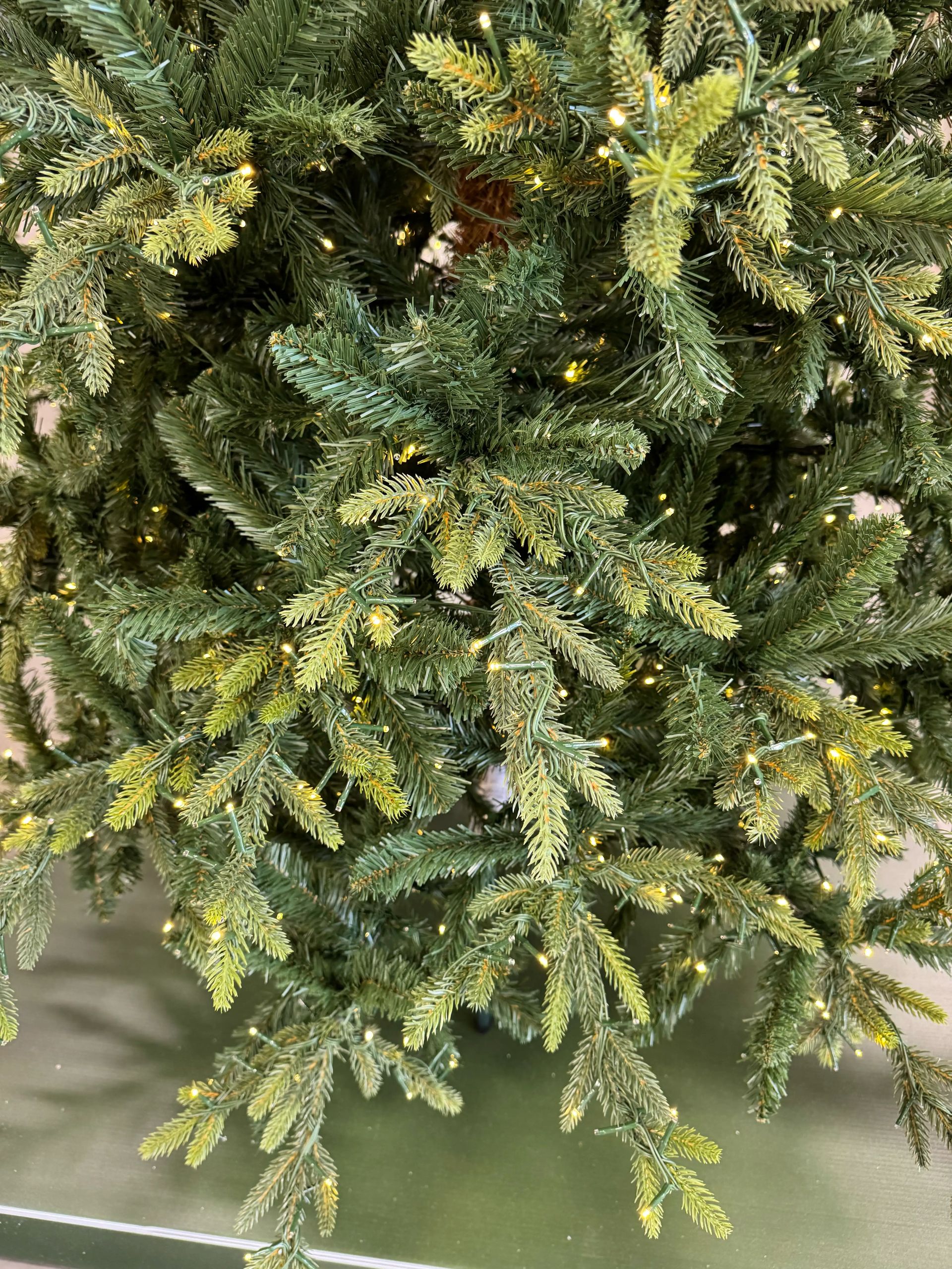 Dense mix of green PVC and molded PE spruce needles with yellow-tipped frosting, warm micro LEDs throughout branches